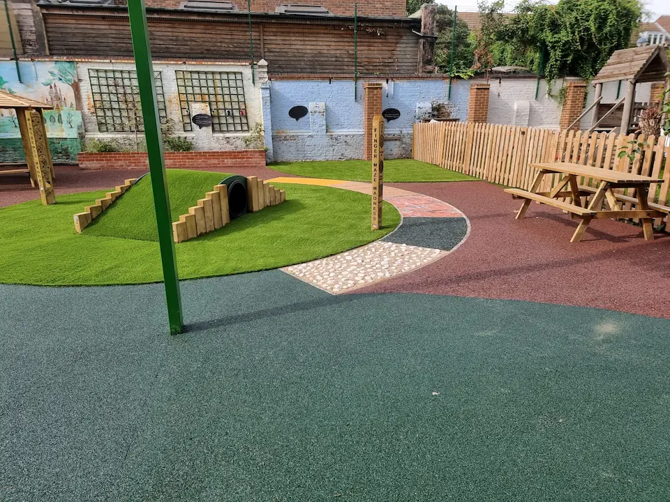 Playground with multiple surfacing materials including EPDM, artificial grass, and more