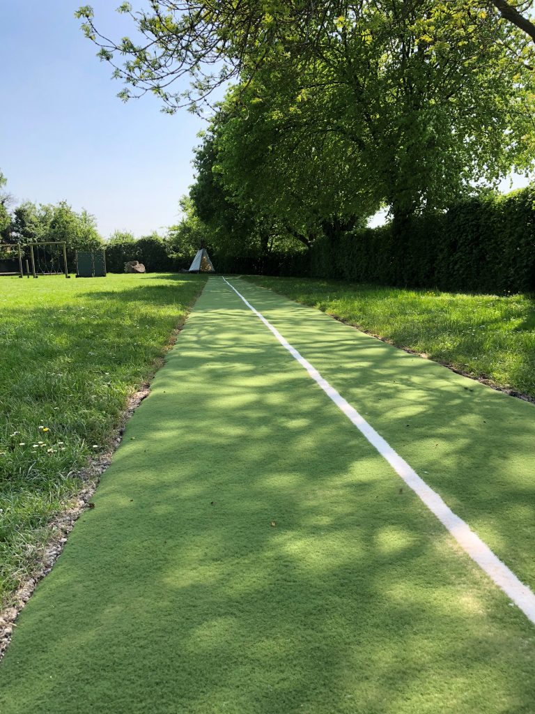 Green artificial grass running track in field