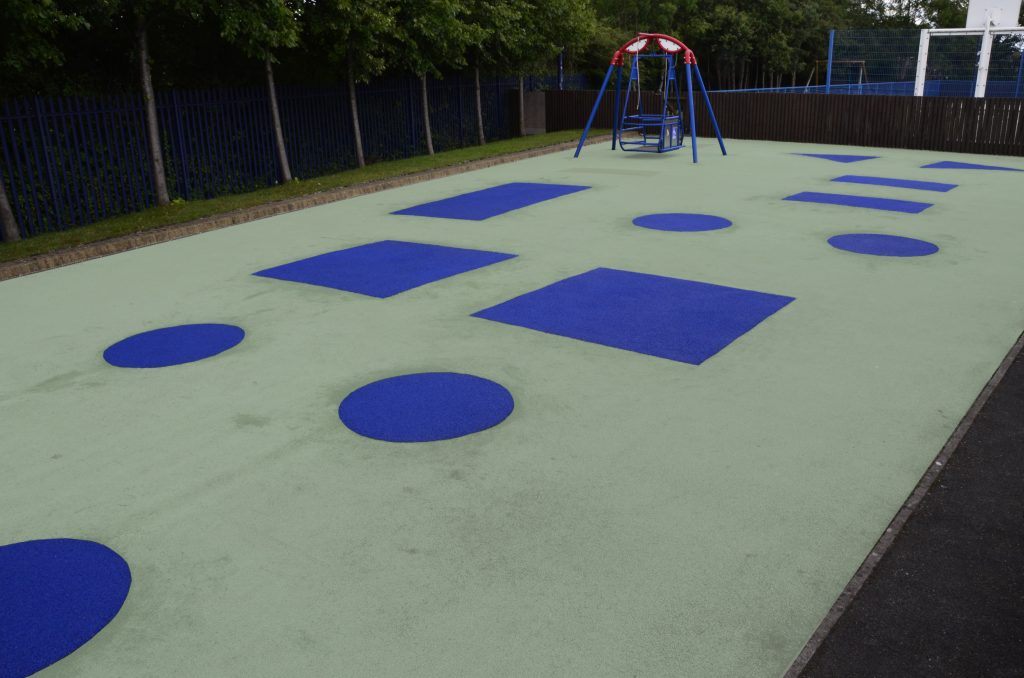 Step 4 - Finished Wet Pour Repair with blue rubber shapes on green surface