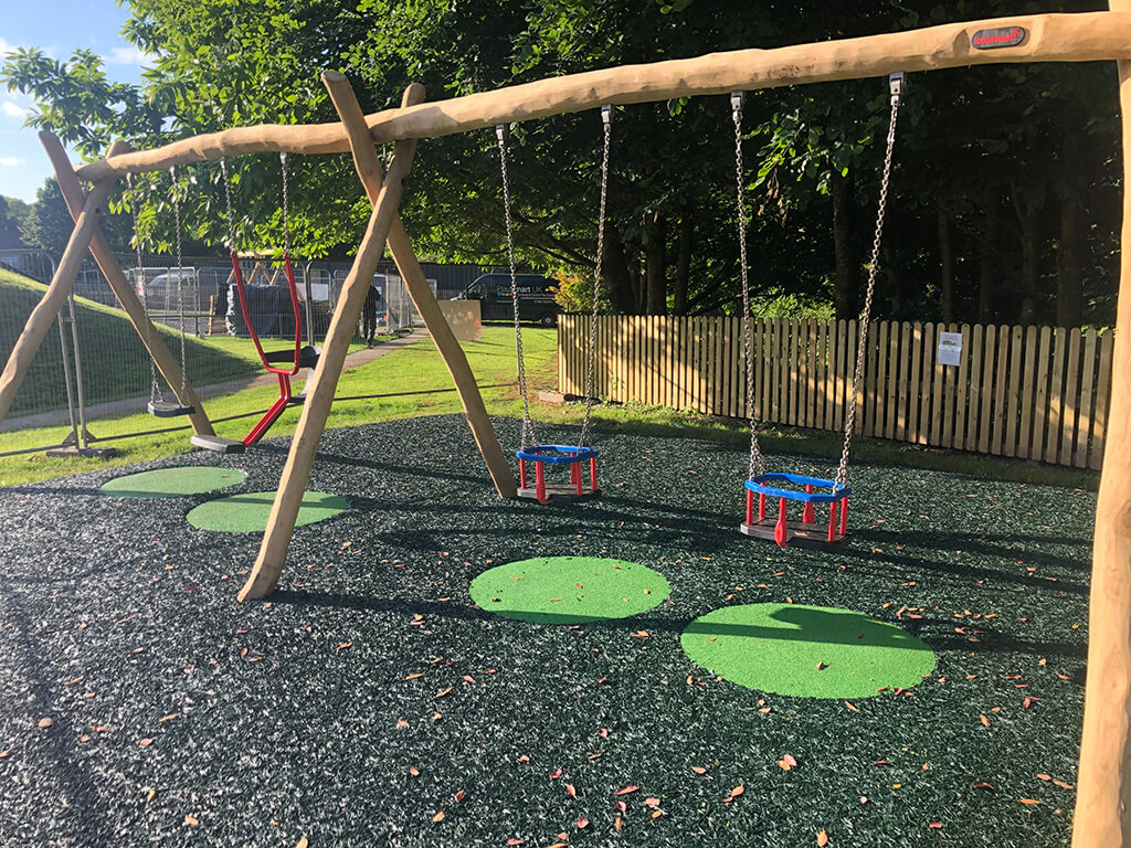 Green Circular Epdm wear pads under swings to provide extra fall protection