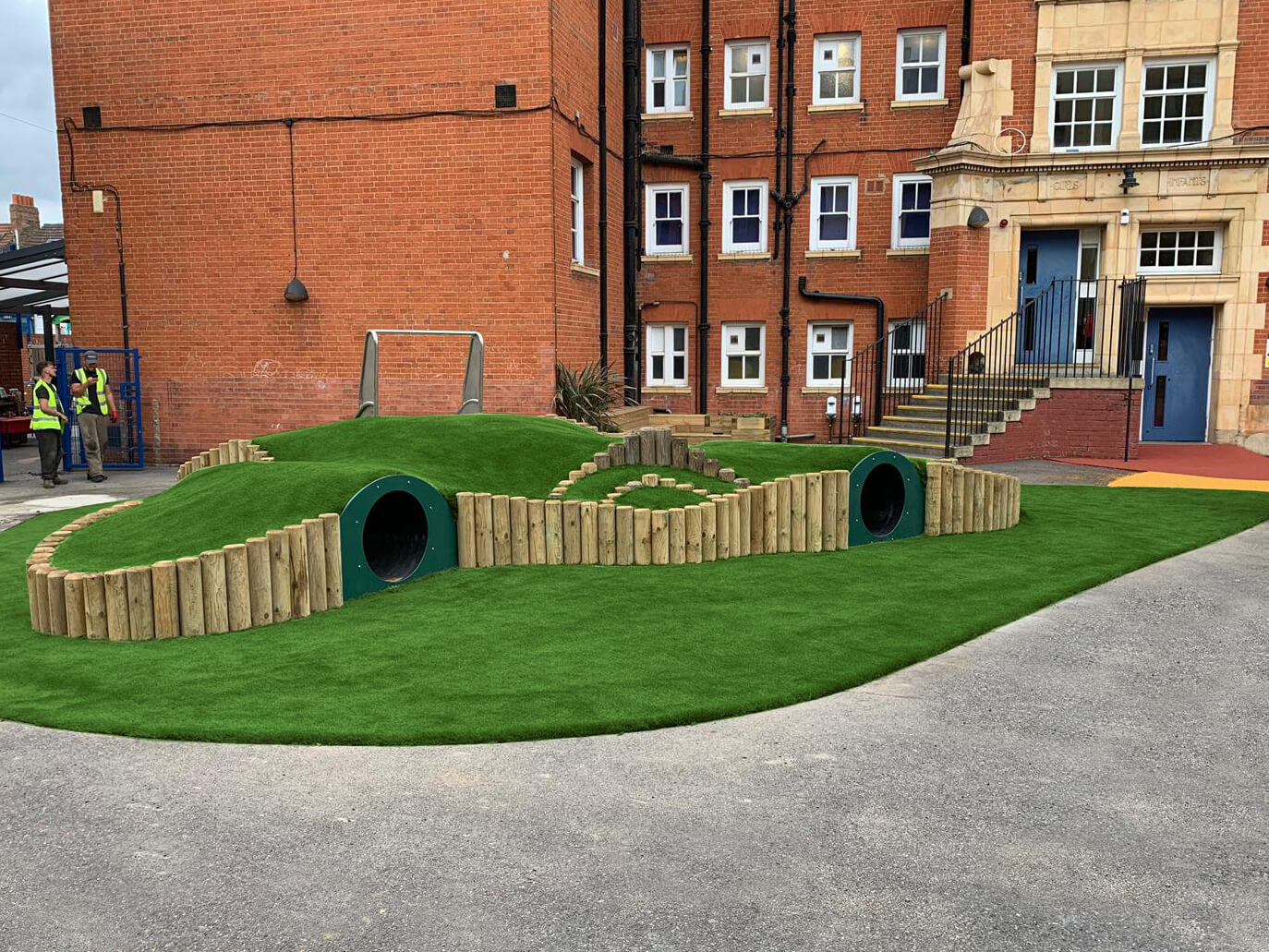 Green Frog Artificial Grass installed for a school over play tunnel mounds