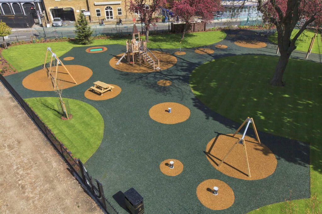Rubber playground with colourful dot design around playground equipment