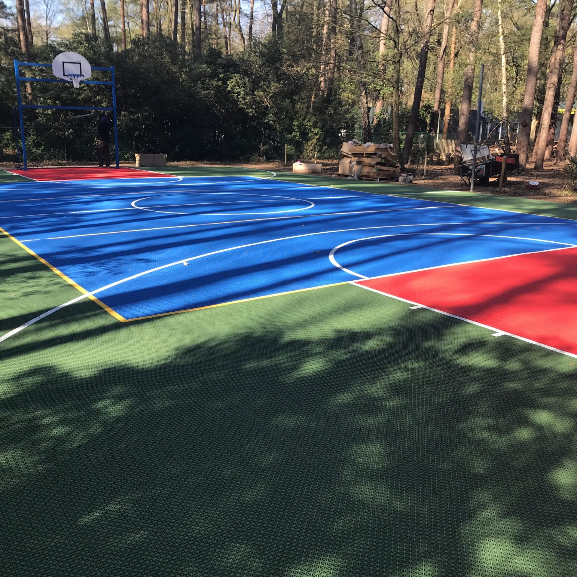 Rubber sports court with vibrant blue, red, and green colours of FlexCourt