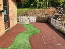 artificial grass pathway through red rubber mulch