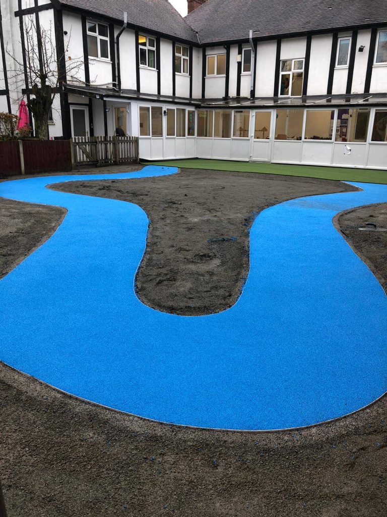 Blue safety surfacing installation, wetpour winding pathway