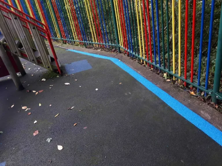 Blue EPDM wear strip around black wetpour playground