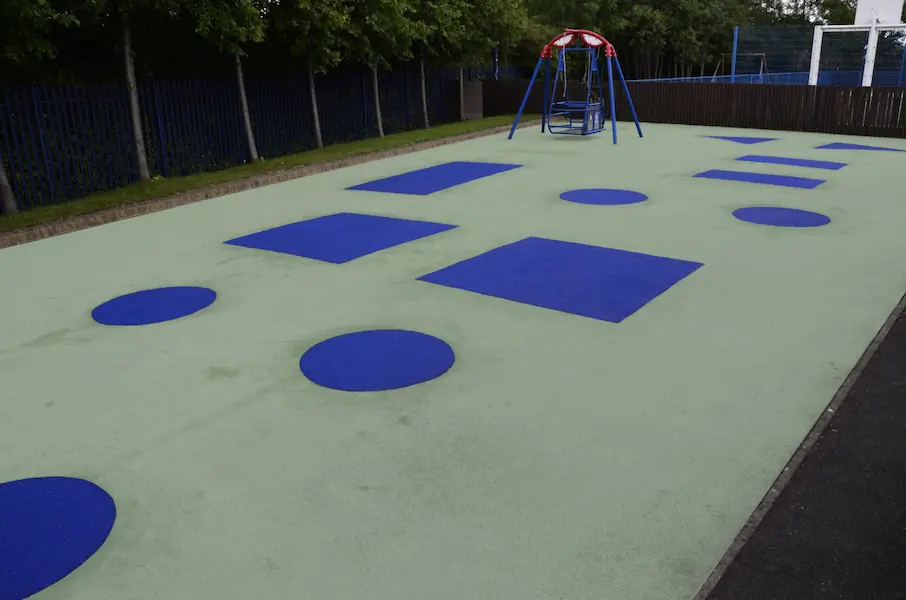 playground wetpour surfacing with blue shape markings and swing