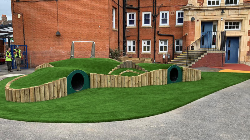 Artificial grass installed at a school over an obstacle tunnel course