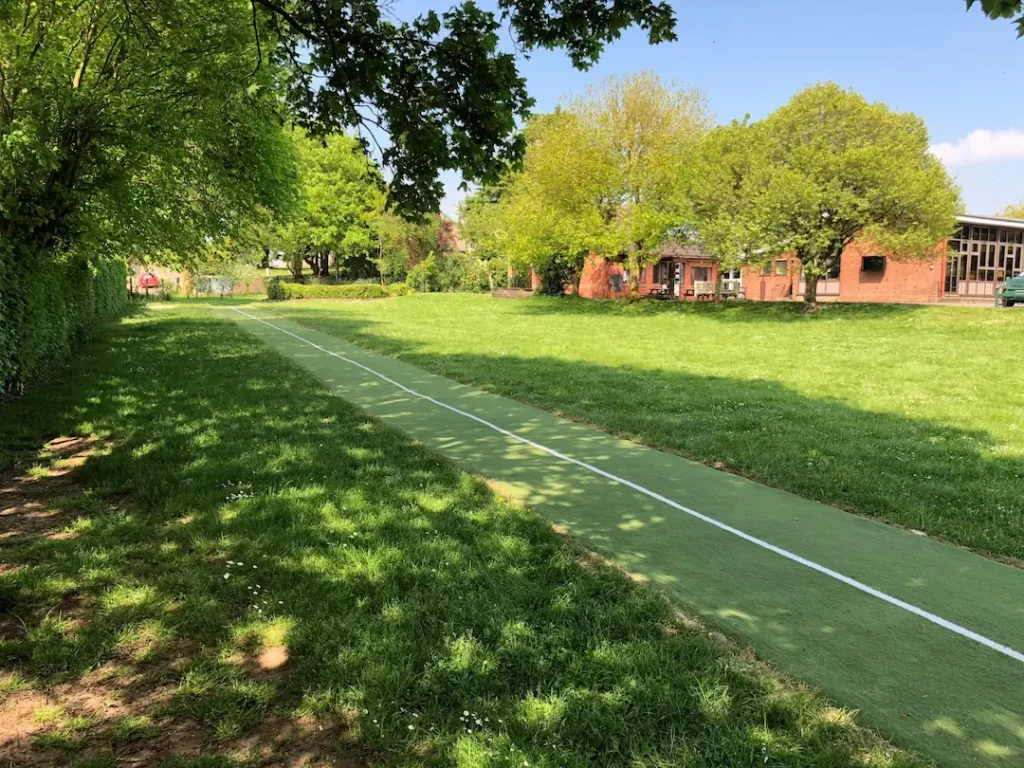 Green artificial grass running track in field