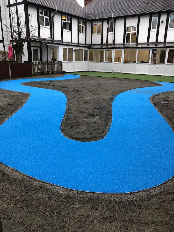 Blue safety surfacing installation, wetpour winding pathway