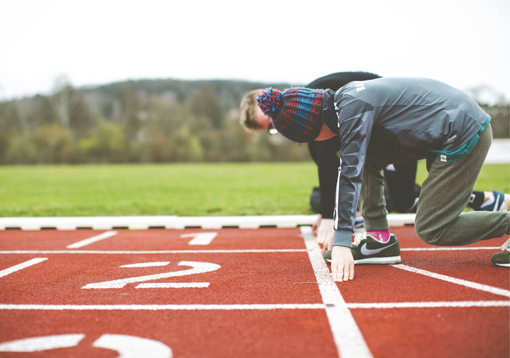 Children at the starting lien of a classic red running track