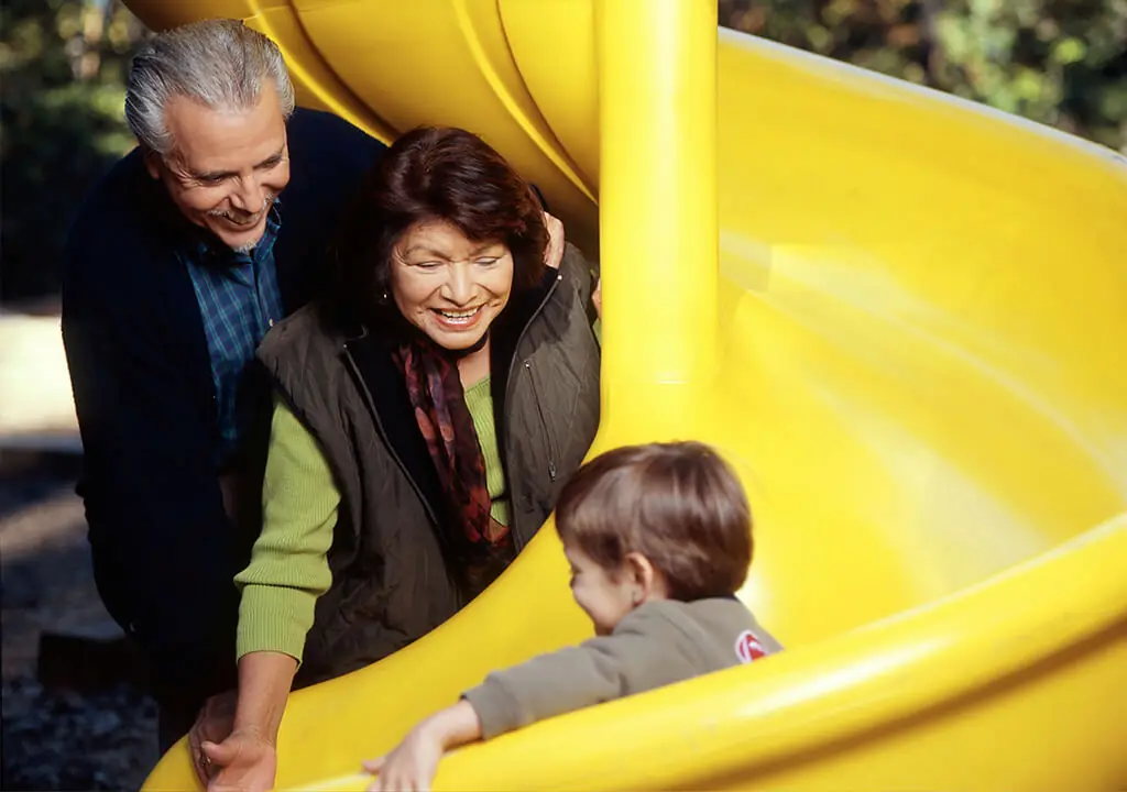 Child enjoying slide in outdoor play environment