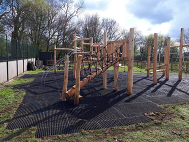 FireSmart rubber grass mats installed on a playground under timber play structures
