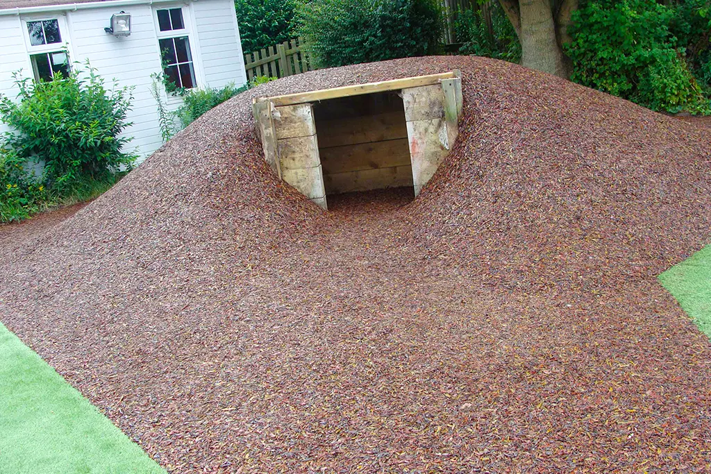 Rubber Mulch fitted around small play den in a mound