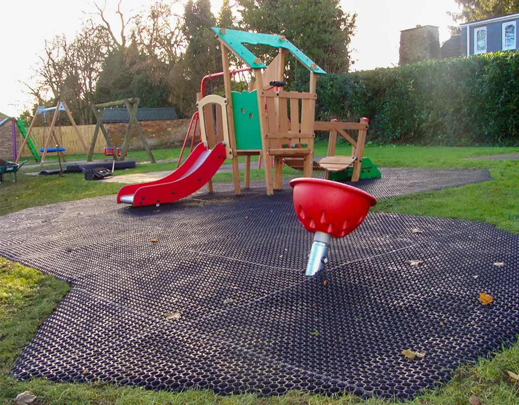 Rubber grass mat surfacing installed underneath a play tower