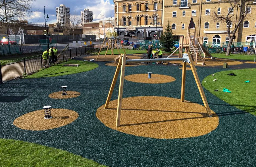 Rubber Mulch Playground with dark blue base and yellow circles around equipment