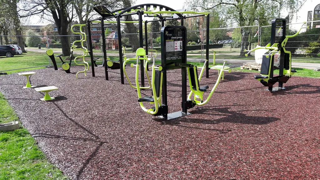 Red JungleMulch surfacing underneath outdoor gym equipment