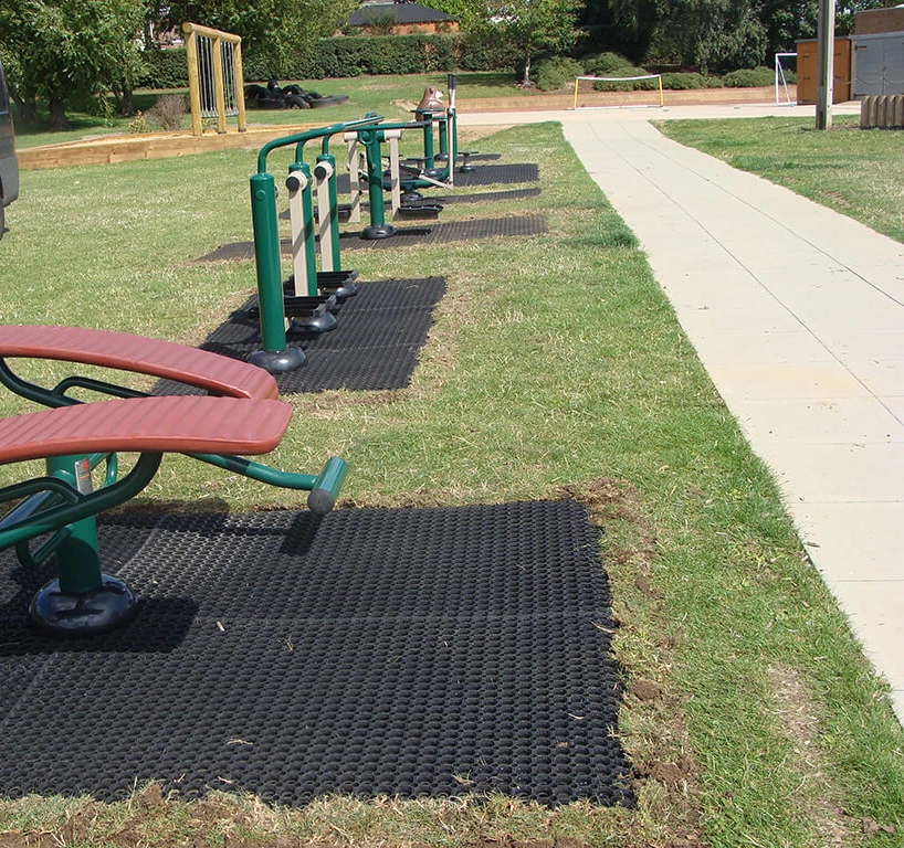 EcoSmart Surfacing for Outdoor Gyms. Black rubber mat squares underneath outdoor fitness equipment