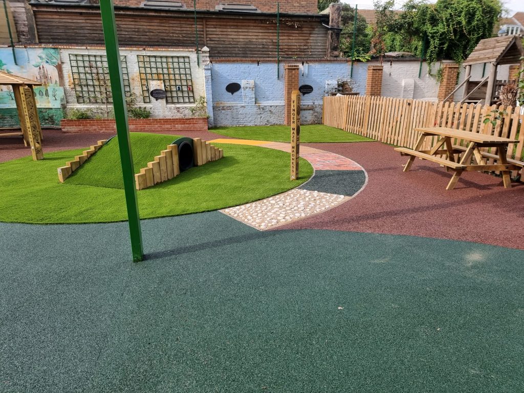 Playground with multiple surfacing materials including EPDM, artificial grass, and more