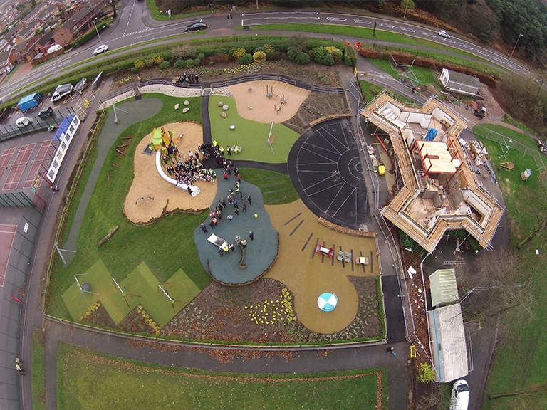 Aerial view of large playground using a variety of surfacing types