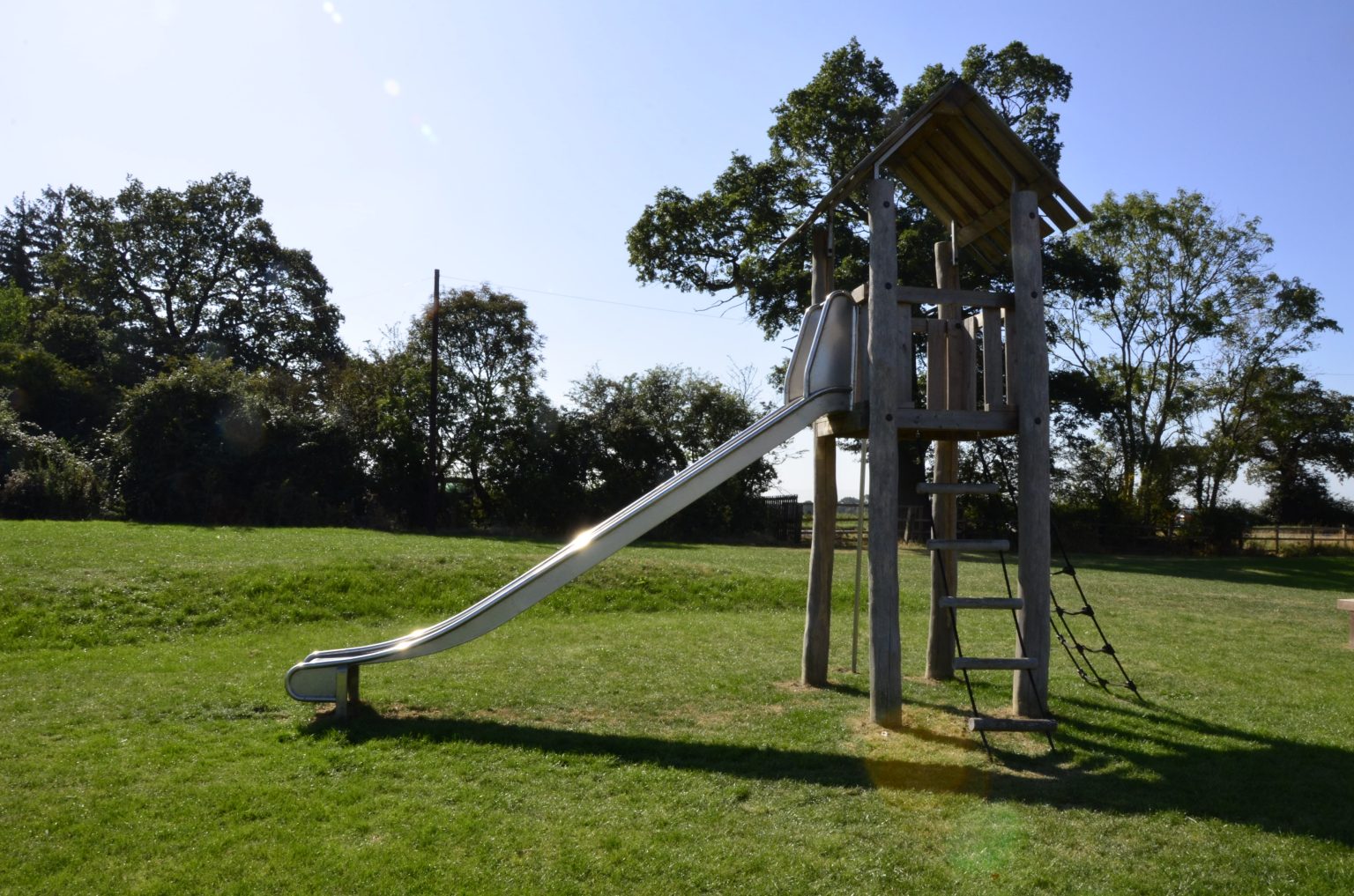 SmartPlay safety surfacing installation on a playground with grass growth hiding the grass mats.