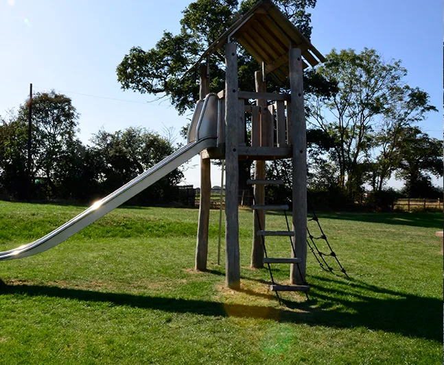 SmartPlay safety surfacing installation on a playground with grass growth hiding the grass mats.