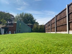 Square of Lush Lawn Artificial Grass installed in a small fenced garden