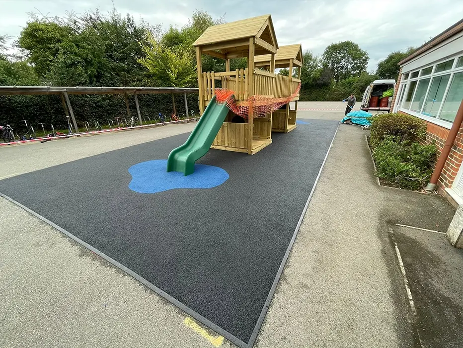 EPDM Mulch area with blue splash below multiplay slide in playground