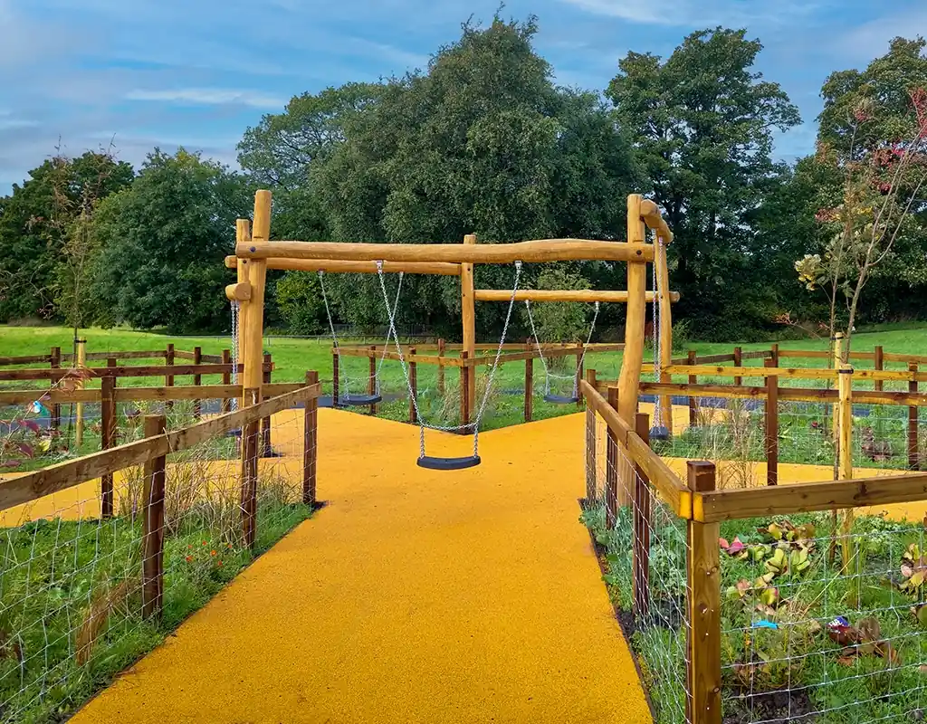 Branching Corkeen pathway under a timber swing structure in a country garden