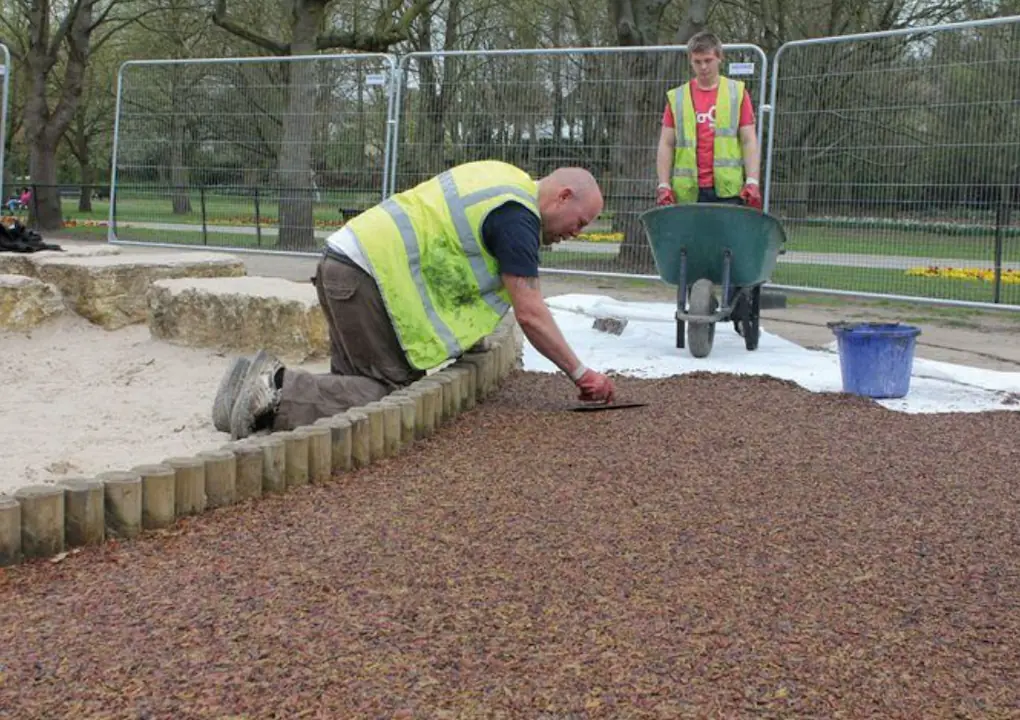 PlaySmart workers installing rubber mulch surfaces
