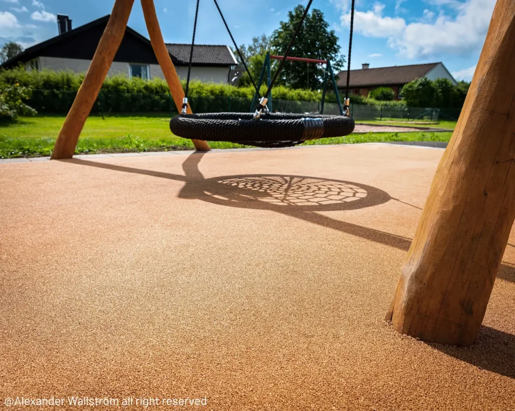 Corkeen play area with a basket swing with a timber frame