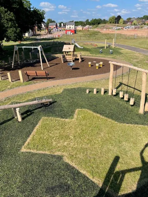 EcoSmart in a park play area with substantial grass growth and JungleMulch
