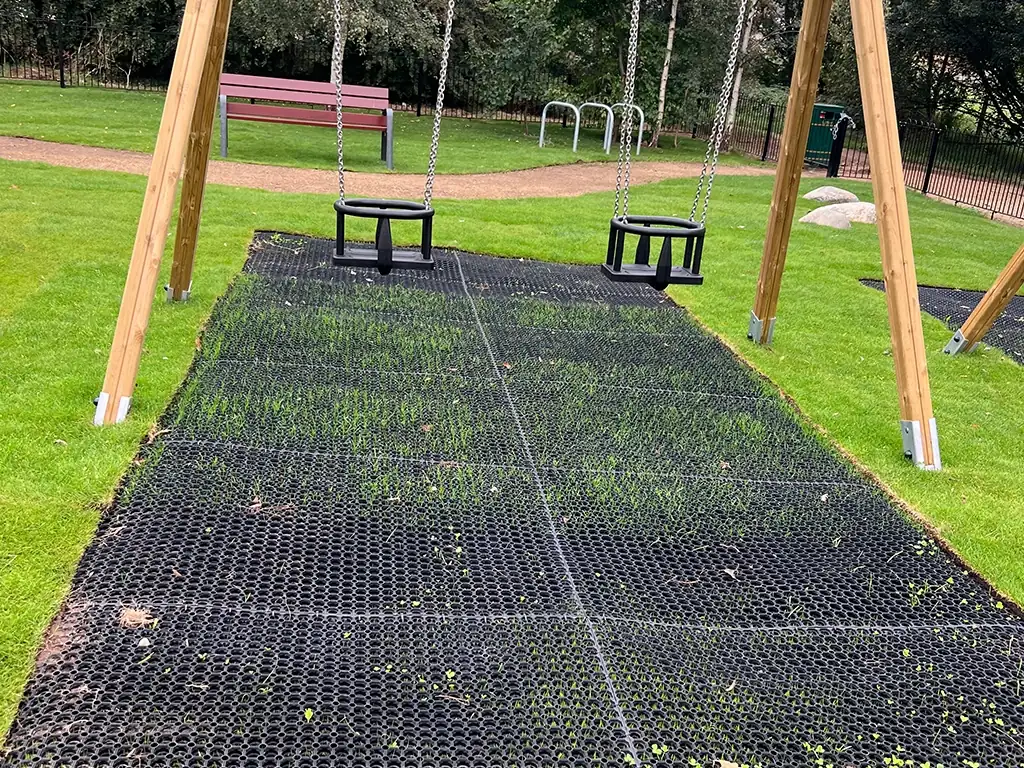 EcoSmart under a dual swing set with partial grass growth in a park