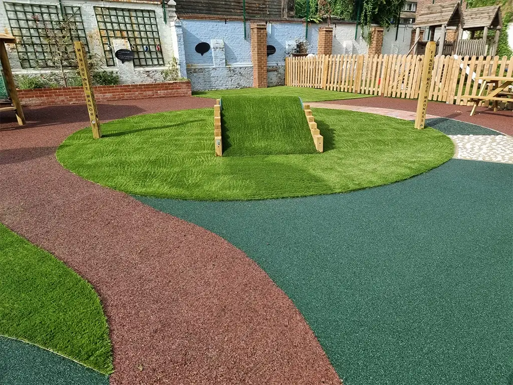 Vibrant EPDM Mulch design around artificial grass in school play area