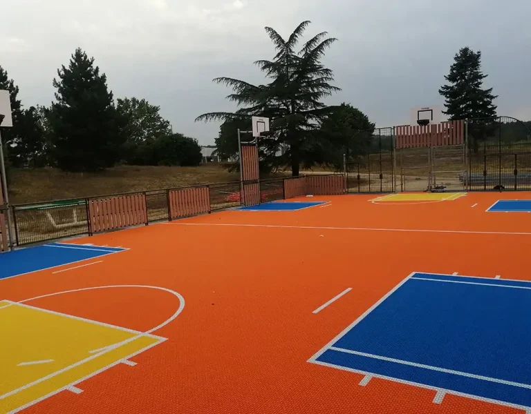 Orange multi use games area MUGA with four basketball hoops and vibrant scoring areas