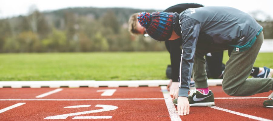 Children at the starting line of a classic red running track