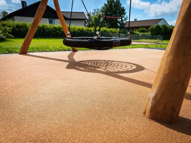 Corkeen play surfacing underneath playground nest swing