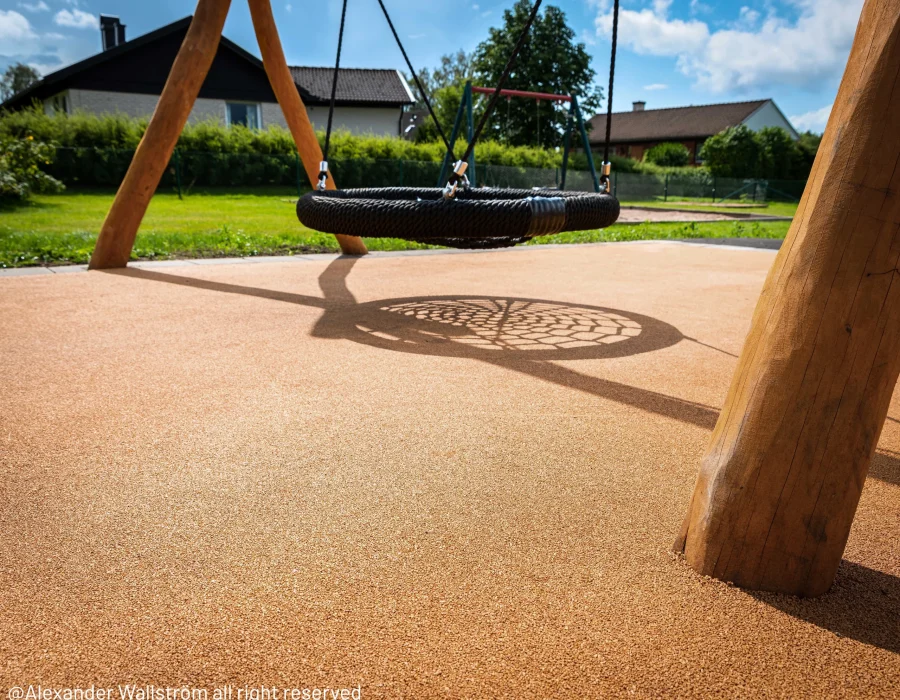 Corkeen play surfacing underneath playground nest swing