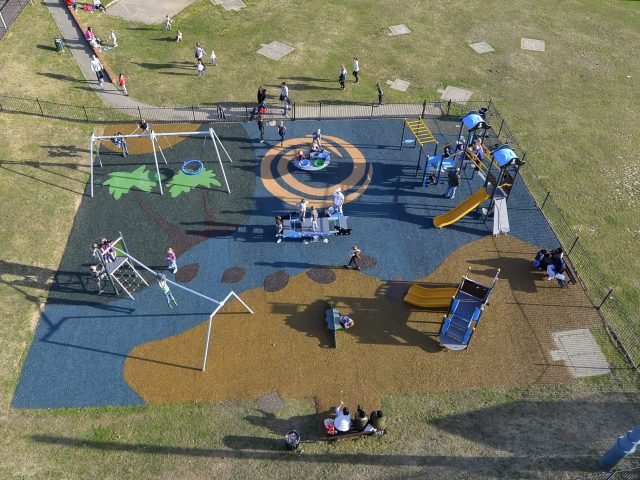 Bending Cresent Playground installation with forest and beach design colourful rubber surfaces