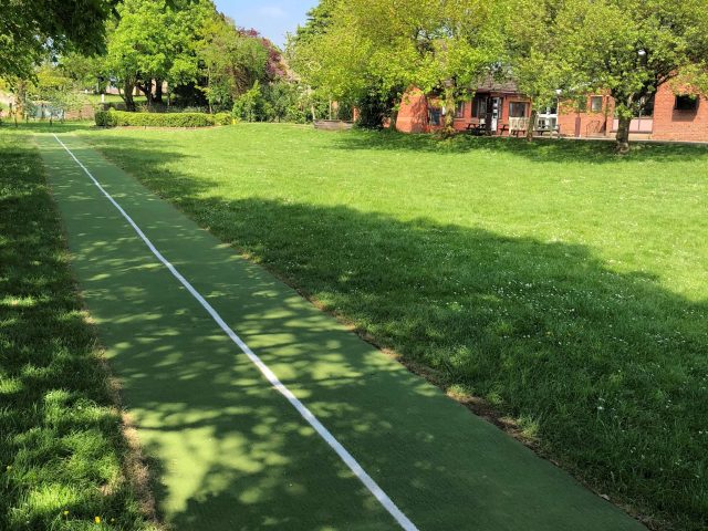 Artificial grass running track surface installation