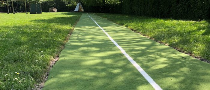 Green artificial grass running track in field