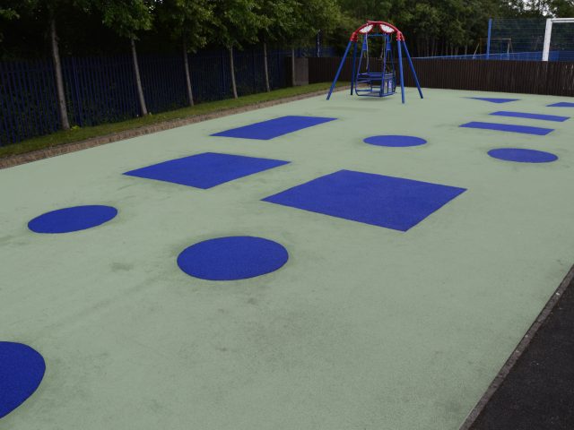 Step 4 - Finished Wet Pour Repair with blue rubber shapes on green surface