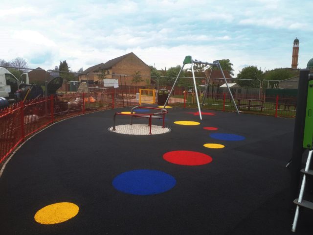 Vibrant dots on black wetpour safety surface installation