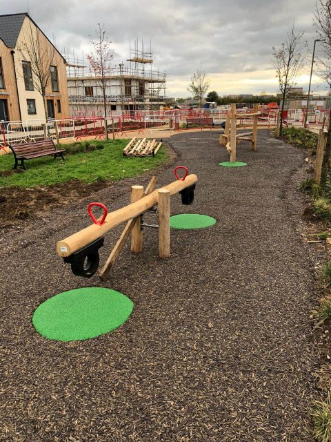 Green EPDM wear pads under playground equipment in JungleMulch residential playground