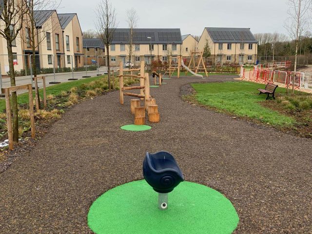 Green EPDM wear pads under playground equipment in JungleMulch residential playground