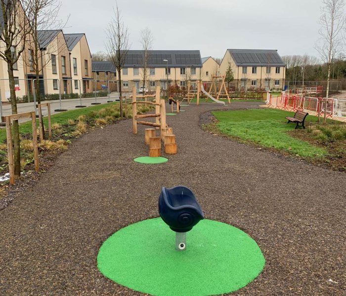 Green EPDM wear pads under playground equipment in JungleMulch residential playground