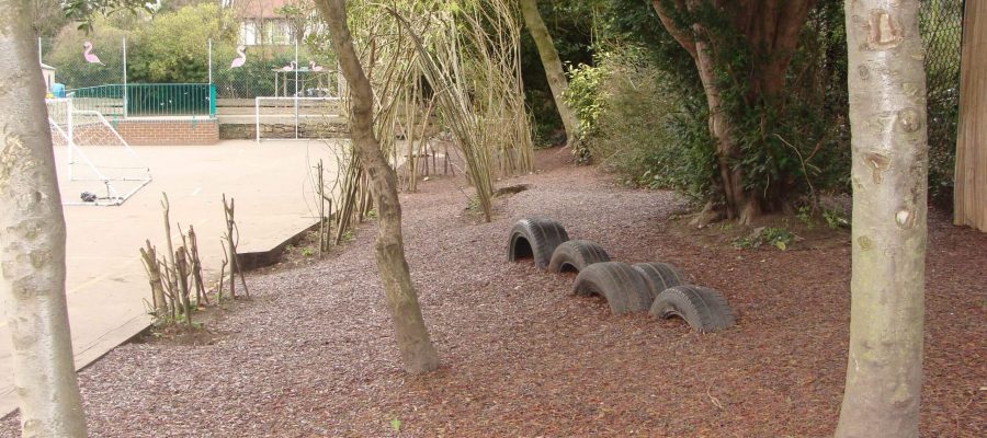 Red rubber mulch surfacing installed as a tree surround