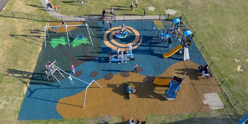 Bending Cresent Playground installation with forest and beach design colourful rubber surfaces