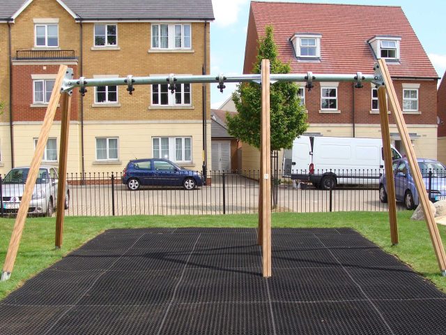 Rubber grass mat square underneath a residential swing set