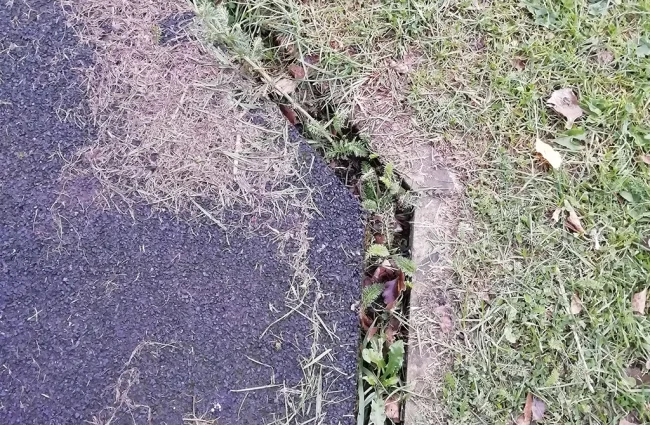 Edge of wetpour rubber surfacing shrinking away from edge